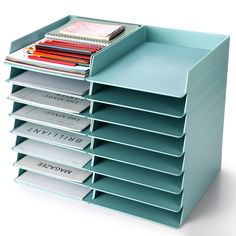 a stack of magazines and folders in a blue holder on a white background with clippings