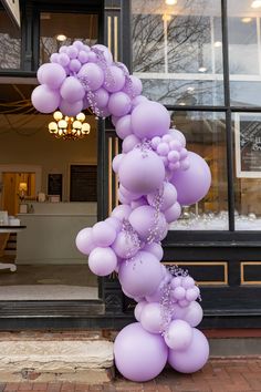 a bunch of balloons that are in front of a building