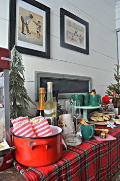 a dining room table covered in christmas food and wine bottles, with pictures on the wall above it