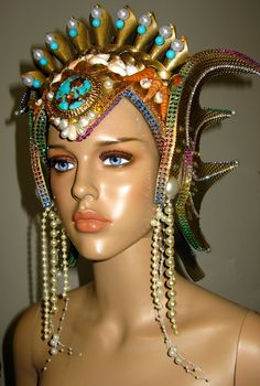 Ocean Queen Headdress, was made in strong but very light weight foam, decorate with gold paint, glitter, natural and handmade shells, rhinestones, pearls, metallic trims, natural turquoise beads and a natural turquoise and cooper front stone. The headpiece is lined with felt and have adjustable elastic on the back. Any question let me know. Thank you Fantasy Costume Party Hat With Round Crown, Fantasy Round Crown Costume Hat For Costume Party, Fantasy Costume Hat With Round Crown For Costume Party, Fantasy Costume Hat With Tall Crown For Festivals, Fantasy Tall Crown Costume Hat For Festival, Carnival Costume Headpiece With Round Crown, Whimsical Crown Costume Hat For Carnival, Fantasy Party Hat With Pinched Crown, Fantasy Party Hats With Pinched Crown