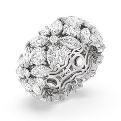 a white gold and diamond ring with an intricate design in the center, surrounded by smaller diamonds