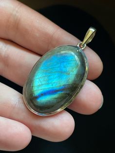 This oval Labradorite pendant is handmade and set in solid Sterling Silver. Each unique Labradorite stone has opalescent colors and shimmering patterns that are pure magic! Labradorite is in the Moonstone and Spectrolite mineral family and gets its name from the place it was originally discovered: Labrador, Canada. It is often referred to as a "Dream Stone" as it enhances the power of dreams and manifestation. Labradorite has the power to help you make your dreams come true! Shoot for the stars! Oval Moonstone Natural Stones, Oval Natural Moonstone Gemstones, Oval Labradorite Cabochon Jewelry, Oval Cabochon Labradorite Jewelry, Oval Moonstone Gemstones With Spiritual Style, Labradorite Gemstone Oval Pendant Jewelry, Oval Labradorite Gemstone Pendant, Oval Labradorite Gemstone Pendant Jewelry, Unique Oval Labradorite Jewelry