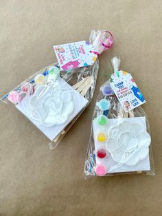 two plastic bags filled with craft supplies on top of a table