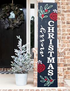 a christmas sign sitting next to a potted plant