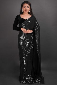 Introducing Elana Black Viscose Georgette Sequins One Minute Saree in an alluring black with clear water sequins that will make your presence more opulent. Paired with a softer velvet blouse for that extra touch of elegance. Product Features: Saree Color: Black Blouse Color: Black Saree Fabric: Viscose Georgette Blouse Fabric: Velvet Saree Work: Sequins Wash Care: Dry Clean Occasion: Party , Cocktail Party ,Wedding Reception Package Content: Saree Disclaimer: There will be slight difference in d Black Sequined Pre-draped Saree For Festivals, Glamorous Black Pre-draped Saree With Sequins, Cocktail Party Wedding Reception, Glamorous Black Georgette Saree, Festive Black Pre-draped Saree With Sequins, Black Semi-stitched Pre-draped Saree With Sequins, Reception Sarees, One Minute Saree, Black Satin Blouse