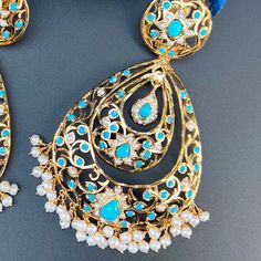 Design inspired from the Edwardian Era, these handcrafted jadau earrings have been made in sterling silver with 22K gold plating and embellished with freshwater pearls and turquoises. The earrings have a clip at the back and a threaded screw. Weight : 50 GMs, Height : 10 cm, Width : 5.5 cm Elegant Turquoise Kundan Earrings, Elegant Turquoise Meenakari Earrings, Turquoise Kundan Earrings For Wedding, Turquoise Jewelry With Matching Earrings For Festivals, Traditional Turquoise Earrings For Wedding, Turquoise Earrings For Wedding And Festivals, Turquoise Meenakari Earrings For Wedding, Elegant Turquoise Earrings For Festivals, Elegant Turquoise Earrings For Festive Occasions