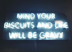 a neon sign that says, mind your biscuits and life will be granny on it