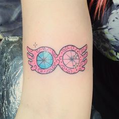 a tattoo on the arm of a woman with pink and blue eyeballs in it