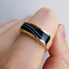 A solid and substantial gold band, set with a polished, elongated piece of banded agate to the face, with full British hallmarks for 9ct gold, dated 2002. A great band for stacking, suitable for both men and women.Hallmarked as 9ct gold, dated Sheffield 2002.Maker's mark "MD".The face of the band measures approximately 6.4mm wide.The shank measures approximately 4.5mm wide.The approximate weight is 6.1 grams.Please note that the antique ring box pictured is for display purposes only. Thank you.R Antique Ring Box, Gold Pearl Ring, Antique Ring, Banded Agate, Agate Ring, Small Rings, Great Bands, Maker's Mark, Gold Pearl