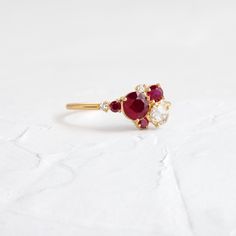 Round ruby focal (5mm, SI clarity). Side cluster stones ranging from 1.5mm to 3.5mm, SI1 clarity, G+ color round and round rose cut diamonds, AA round natural rubies. Solid 14k gold setting with a delicate 1.2mm round band. Also available in platinum. We handcraft each piece with responsibly sourced metals and ethically sourced stones. White Accents, Natural Ruby, Gold Set, Rose Cut Diamond, Cluster Ring, Rose Cut, Diamond White, Ruby, Gold Color