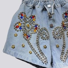 Uncover the perfect balance of classic vibe and modern charm with our 2023 Summer Collection's flower ornament embellished denim shorts. With a high-waist. free silhouette. these y2k inspired shorts are accented with buttons and rubber closure for a secure fit. Make a statement in these versatile shorts and step into the season with timeless style and effortless grace!Distinctive Features: Y2K-Style: An ode to the past. fashionably reimagined with a modern twist. High-Waist: Captivatingly cinche Y2k Style Spring Shorts, Spring Denim Blue Bottoms With Rhinestones, Denim Blue Embellished Bottoms, Y2k Denim Blue Jean Shorts For Summer, Spring Denim Blue Rhinestones Bottoms, Denim Blue Rhinestone Bottoms For Spring, Denim Blue Rhinestones Bottoms For Spring, Spring Denim Jean Shorts With Rhinestones, Trendy Embellished Denim Blue Bottoms