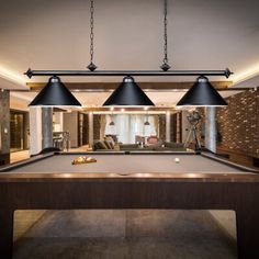 a pool table with three lamps hanging over it