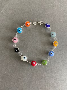 Multi-Color Evil Eye Bracelet Tiny Evil Eye charm, Greek Eye Bracelet, Turkish Eye Bracelet - Sterling Silver ★ Quantity : One Piece ★ Type : A / B / C / D / E / F / G ★ Materials : Sterling Silver ★ Each Evil Eye Size : 10mm ★ Length : 7.5 inches ★ Suitable for delicate and sensitive skins. ★ All purchases come in a small gift box perfect for gift giving. Multiple items will be boxed together. If you need extra boxes for gifting....just let us know! Evil Eye Types, Handmade Adjustable Multicolor Chain Bracelet, Adjustable Multicolor Handmade Chain Bracelet, Adjustable Handmade Multicolor Chain Bracelet, Rainbow Charms Bracelet As A Gift, Multicolor Round Bracelets As Gift, Multicolor Round Bracelets For Gifts, Nickel Free Multicolor Metal Bracelets, Multicolor Nickel Free Metal Bracelets