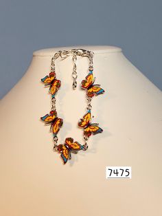 Butterfly charms have great details.  Three colors are combined to make this a lovely bracelet.  Charms are yellow with blue and red and joined with gold plated rings and chain,  Closure is a lobster claw. Bracelet measures approx. 6" to 7.5" Multicolor Dangle Jewelry With Lobster Clasp, Multicolor Hypoallergenic Charm Bracelet, Multicolor Enamel Jewelry With Lobster Clasp, Orange Bracelet With Lobster Clasp, Orange Bracelet Jewelry With Lobster Clasp, Hypoallergenic Multicolor Metal Bracelets, Multicolor Charm Jewelry For Collectors, Collectible Multicolor Charms Jewelry, Nickel-free Multicolor Charm Bracelet For Jewelry Making