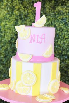 a pink and yellow cake with lemons on it