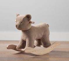 a wooden rocking toy with a teddy bear on it