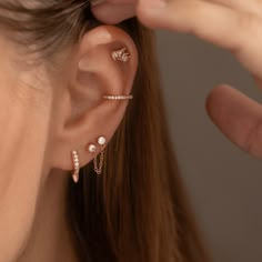 a close up of a person's ear with three piercings