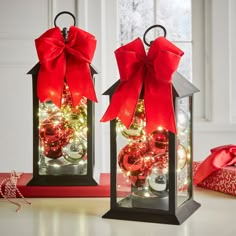 two lanterns with bows and ornaments in them