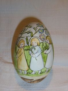 an easter egg decorated with children and flowers