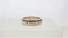 "\"Ani L'Dodi V'Dodi Li BAND ROLLING RING\" This beautiful rolling band ring is made of 925 Sterling Silver and 9 kt gold. ( Marked 925 and 9K) Size: 6, 7, 8, 9, 10,11 Engraved in Hebrew letters: \"Ani L'Dodi V'Dodi Li\" \"I am my beloved's and my beloved is mine,\" - Song of Songs (Shir HaShirim), Chapter 6, verse 3A. Many phrases from The Song of Songs written by King Solomon, have been used throughout weddings for centuries. When you read the entire poem from where this phrase comes from, it Spiritual Engraved Wedding Ring, Spiritual White Gold Wedding Rings, Spiritual White Gold Rings For Wedding, Traditional White Gold Engraved Wedding Ring, Traditional Engraved White Gold Ring For Wedding, Spiritual Yellow Gold Stackable Rings For Wedding, Handmade Wedding Couple Rings, Yellow Gold Stackable Wedding Rings, Handmade Yellow Gold Stackable Wedding Rings