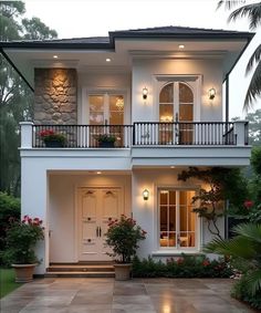 a white two story house with lots of windows and balconies on the second floor