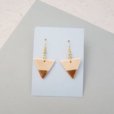 A pair of pink glazed porcelain triangle dangle earrings with 22k gold lustre detail. Ear posts are gold plated hypoallergenic fish hooks for pierced ears. They will be supplied with clear rubber stoppers.The porcelain triangles are fired 3 times to achieve this finish and are very lightweight and durable. Please note the earrings are only glazed on one side due to the nature of the process. The back will be the pure white of the porcelain.The triangles measure approx 2.5cm wide x 2cm high and w Gold Triangle, Fish Hooks, Earrings Geometric, Triangle Earrings, Round Stud Earrings, Geometric Jewelry, Stunning Earrings, Grey And Gold, 22k Gold