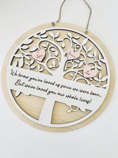 a wooden plaque with a tree and two hearts on it