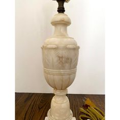 a white vase sitting on top of a wooden table