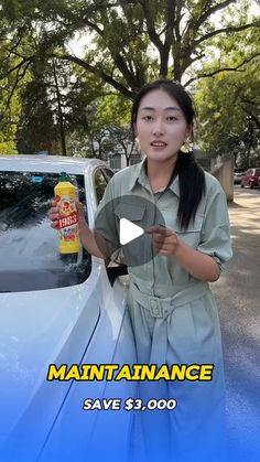 a woman standing next to a white car holding a bottle of mustard and ketchup