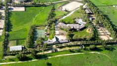 an aerial view of a large farm with lots of grass and trees in the foreground