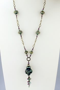 "Discover the beauty of handmade lampwork glass beads in this enchanting new long necklace and earrings set. The handmade glass beads are a metallic green with plum accents. Paired with antiqued brass chain and Swarovski crystals. The focal is an urn shape hollow bead. I have accented the focal with Swarovski crystals in coordinating colors, wire wrapped the accent beads to antique brass chain and finished it with a heart lobster clasp closure. Much prettier in person! This one of a kind lampwor Jewelry Assemblage, Lampwork Bead Necklace, High Strung, Green Plum, Lampwork Bead Jewelry, Vintage Jewelry Ideas, Lampwork Necklace, Beaded Things, Crafting Jewelry