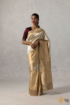 "A lustrous pure Katan silk saree in a\u00a0harmonious\u00a0combination of\u00a0beige and gold.\u00a0Its plain body is\u00a0edged with an ornately handwoven border,\u00a0depicting\u00a0a medley of floral vines, geometric patterns, and a\u00a0dynamic\u00a0rendition of lines of varying widths.\u00a0\n\n\nColor\u00a0- Elegant shades of\u00a0Beige and\u00a0Gold\n\nFabric\u00a0-\u00a0Soft as butter, pure Katan silk\u00a0\n\nTechnique\u00a0-  An enduring Kadwa weave. The elaborate and laborious Kadwa (Kadhua) technique involves hand-weaving each motif separately. It takes longer on the handloom, but makes a more robust pattern, which stands out on the fabric.\n\n\nTilfi Promise\u00a0- Pure. Handloom. Banaras.\n\nNote\u00a0- The saree comes with its own blouse piece. The\u00a0model is wearing a s Luxury Beige Saree With Zari Weaving, Luxury Katan Silk Cream Saree, Luxury Cream Katan Silk Saree, Luxury Gold Katan Silk Pre-draped Saree, India Inspired, Katan Silk Saree, Katan Silk, Shades Of Beige, Gold Fabric