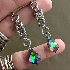 Handmade Maille & Purple Blue Green Pink Rainbow Iridescent Rainbow Austrian Crystal Dangly Earrings . Earrings Posts Are Stainless Steel . To Create The Maille Links I Use Stainless Steel Hoops As Well . It Is Nickel Free , Allergy Free , Hypoallergenic , No Itching , Do Not Change Color , Rust Or Turn Skin Green . Handmade By Me Any Questions Lmk ! Handcrafted / Boho / Bohemian / Boho Chic / Gypsie / Hippie / Festival / Goth / Gothic / Viking / Medieval / Victorian / Rock & Roll / Rocker / Roc Iridescent Pierced Drop Earrings, Rainbow Dangle Metal Earrings, Single Dangle Stainless Steel Earring, Handmade Stainless Steel Dangle Jewelry, Hypoallergenic Rainbow Colored Metal Jewelry, Hypoallergenic Rainbow Metal Jewelry, Stainless Steel Single Dangle Earring, Nickel-free Rainbow Drop Earrings, Rainbow Nickel-free Drop Earrings