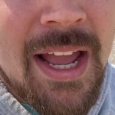 a close up of a man's face with a toothbrush in his mouth