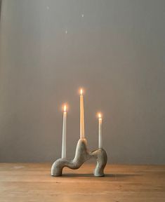 three candles are lit on a wooden table