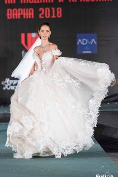 a woman in a wedding dress walking down the runway