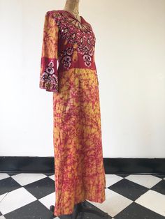 "1970's batik cotton maxi dress has small round mirror applique across the front/back bodice and sleeve cuffs trimmed in yarn embroidery. The dress has a v-neck with fold over lapels, hip pockets and there's a back metal zipper for closure. Label is Ramona Rull. Made in Pakistan. 100% cotton. Condition Overall excellent, has a small on the front skirt. Measurements Bust 36\" Waist 31\" Hip 42\" Shoulder 15.5\" Sleeve length 18.5\" Length 54.5\" Tag size is a small." Long Batik Print Dress For Spring, Long Batik Print Spring Dress, Bohemian Floor-length Batik Maxi Dress, Spring Long Batik Print Dresses, Bohemian Floor-length Maxi Dress With Batik Print, Long Spring Dress With Batik Print, Bohemian Long Sleeve Batik Maxi Dress, Traditional Batik Print Maxi Dress For Spring, Festival Batik Print V-neck Maxi Dress