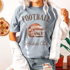 Gear up for game day with our Football Athletic Club Comfort Color Tee. Crafted for comfort and style, this tee is perfect for fans who want to show their support in a laid-back yet spirited way. Emblazoned with the emblem of our Football Athletic Club, this tee exudes team spirit and camaraderie. Whether you're cheering from the stands or watching from home, our tee ensures you'll be representing your team in style. Made from premium materials, this tee offers unparalleled comfort and durabilit Sporty Top With Team Logo For Sports Season, Sports Fan Tops With Team Logo For Game Day, Casual Top With Team Logo For Baseball Season, Casual Tops With Team Logo For Game Day, Casual Tops For Baseball Season Fan Gear, Football Season Tops With Team Logo For Sports Fans, Sports Fan Tops With Team Logo For Football Season, Sports Tops With Team Name For Football Season, Sports Fan Tops With Team Logo For Baseball Season