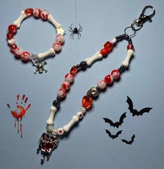 a bracelet with red and white beads on it next to a handprinted spider