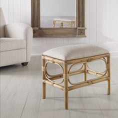 a chair and ottoman in front of a mirror on the floor with white walls behind it