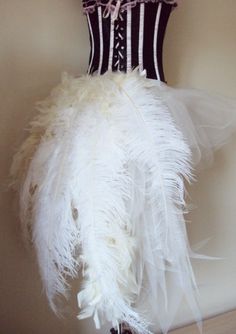 there is a white feather dress hanging on the wall