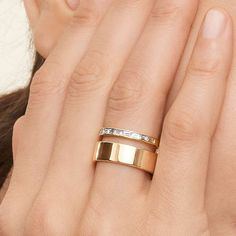 a woman's hand with two gold rings on her left and one in the middle