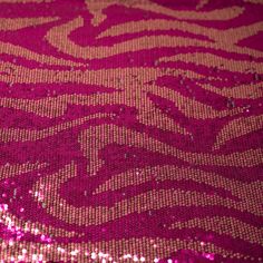 pink and gold sequinized fabric with an intricate design on the bottom half of it