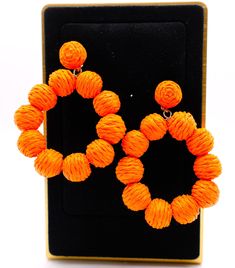 These striking hoop earrings capture the essence of a vibrant sunset on a tropical beach. Designed with bright orange straws that form the hoop, each earring is adorned with small orange balls for an extra touch of playful elegance. The result is a captivating statement piece that can instantly transform any outfit, making it stand out with a burst of color and lively charm. Length: 3 inches Care: Avoid contact with water and cosmetics, such as creams or perfumes. To restore the luster and shine Adjustable Orange Hoop Earrings, Trendy Small Hoop Orange Jewelry, Trendy Small Hoop Orange Earrings, Coral Earrings For Beach Summer, Coral Earrings For Beach And Summer, Coral Earrings For Summer Beach Occasion, Orange Small Hoop Earrings For Summer, Summer Beach Coral Earrings, Orange Summer Earrings For Vacation