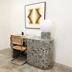 a desk with a chair next to it and a painting on the wall