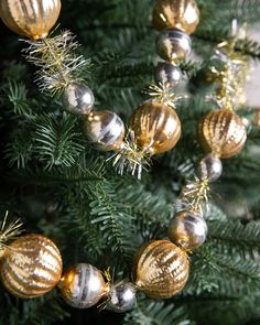 gold and silver ornaments hanging from a christmas tree