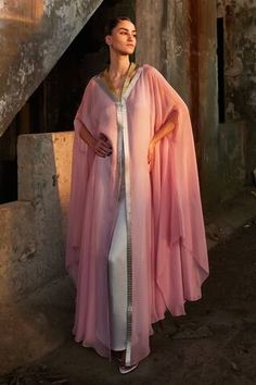 Pink satin organza kaftan with hand-embroidered metallic yarn neckline. Paired with an underlay in complementing color.
Components: 2
Neckline: V Neck
Sleeve Type: Cape
Fabric: Chiffon (100% Viscose), Satin (66% Viscose 34% Modal), Sequin (100% Plastic), Organza (100% Silk)
Color: Pink
Other Details: 
Length: 60 inches
Occasion: Party - Aza Fashions Organza Kaftan, Kaftan Women, Kaftan For Women, King Lear, Metallic Yarn, Pink Chiffon, Fashion App, Abaya Fashion, Pink Satin