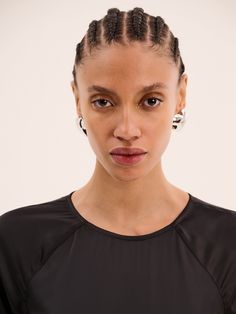 a woman with braids on her head looking at the camera