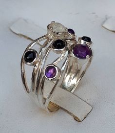 **FREE EXPRESS SHIPPING** Thank you for taking the time to visit my store I'm a jewelry designer for 23 years I am full of giving ,love and positive energies and there is nothing that makes me happier than helping people and making them happy So I put all these energies into my jewelry and when you wear them you will feel it with a lot of love 💖 Sterling Silver ring made of yarns With seven gemstones Five 3 mm amethyst citrine and peridot And two 5 mm Blue Topaz and Moonstone Ring width at the Fusion Rings With Natural Stones For Anniversary, Fusion Style Anniversary Rings With Natural Stones, Fusion Style Natural Stones Ring For Anniversary, Fusion Style Natural Stone Rings For Anniversary, Sterling Silver Stackable Rings With Natural Stones, Silver Sapphire Ring With Natural Stones, Silver Sterling Sapphire Ring With Natural Stones, Sterling Silver Sapphire Ring With Natural Stones, Elegant Silver Stackable Rings With Natural Stones