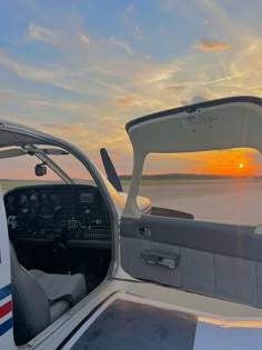 the sun is setting in the distance as seen from inside a small plane's cockpit